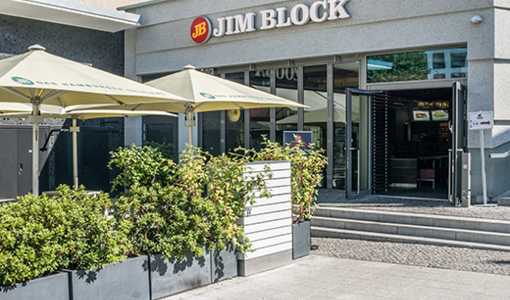 Jim Block Restaurant mit einer Terrasse mit weißen Sonnenschirmen