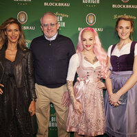 Eine Gruppe von drei Frauen und zwei Männern stehen vor einer Logowand des Blockbräu
